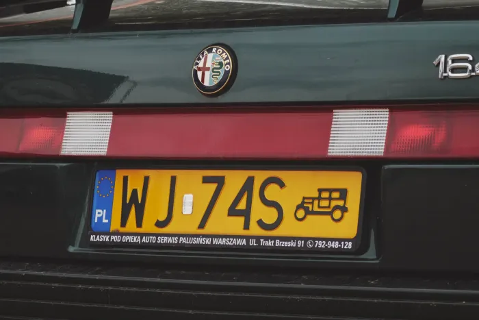 Żółta tablica rejestracyjna pojazdu zabytkowego na Alfie Romeo 164